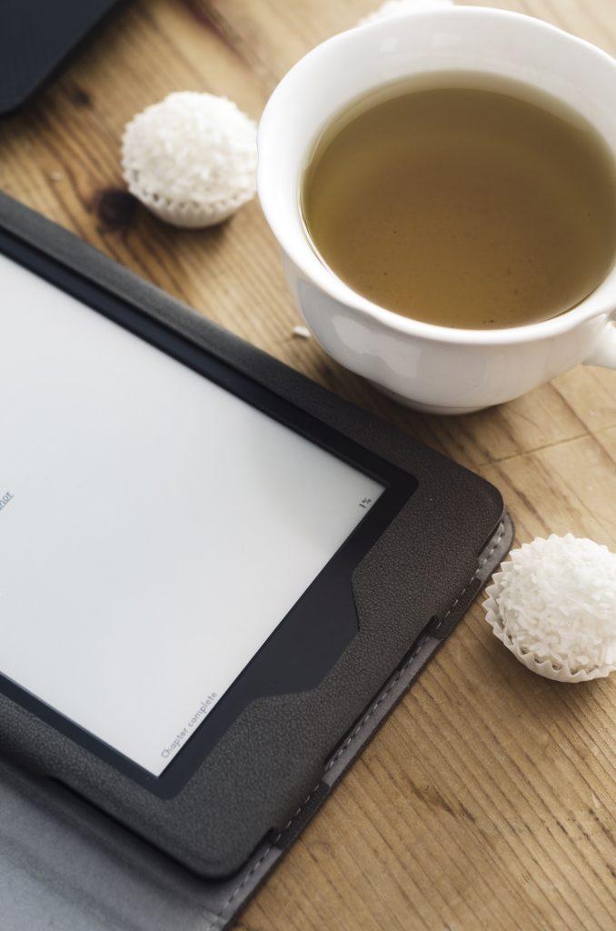 e-reader con tazza ti tè e pasticcino