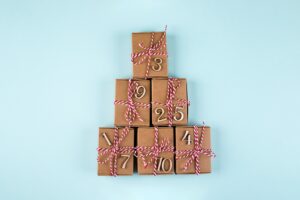 Advent christmas calendar. Wrapped gifts on blue background. Top view, flat lay